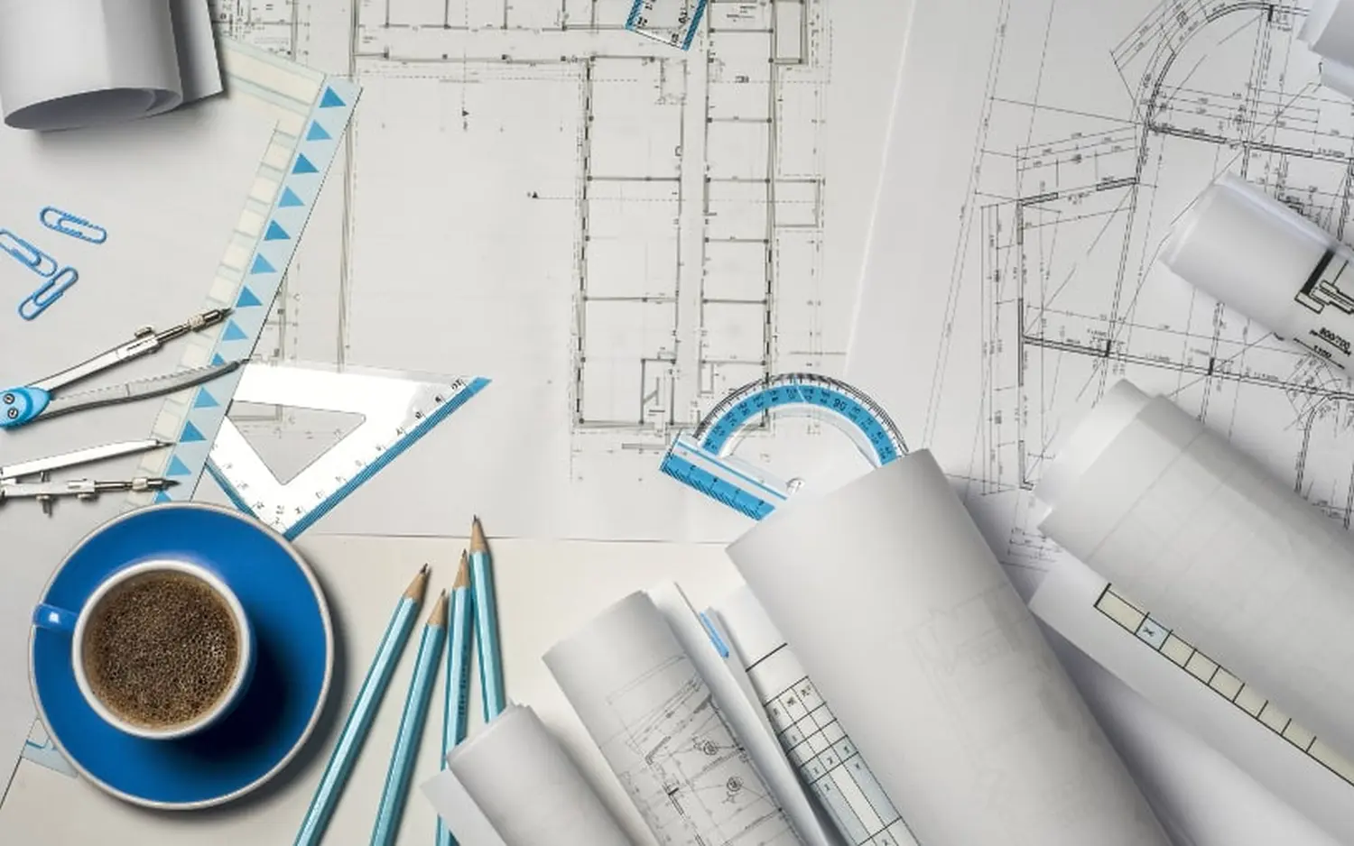 EMshield GmbH - Architecture and Corporate Security - This image shows an architect's or engineer's workspace, featuring various drafting tools and technical documents.